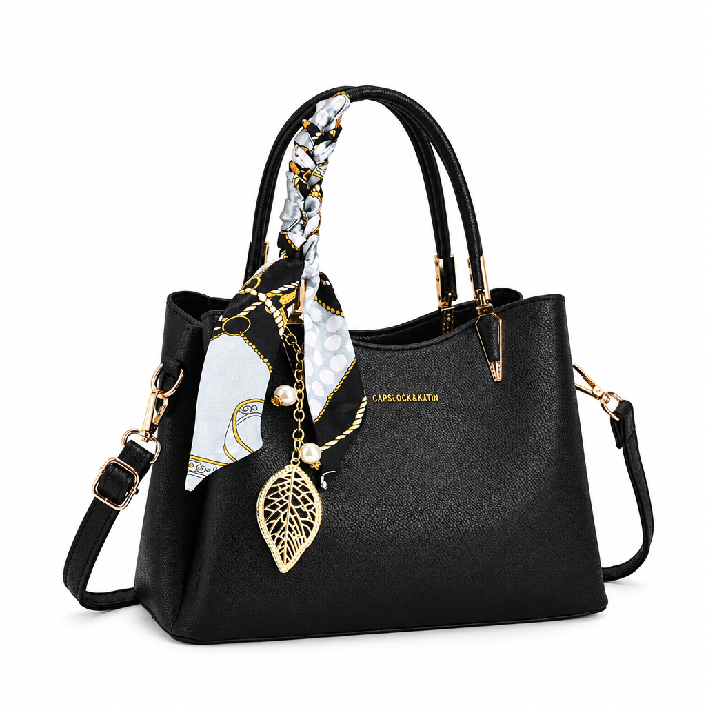 Black handbag with scarf and charm on white background